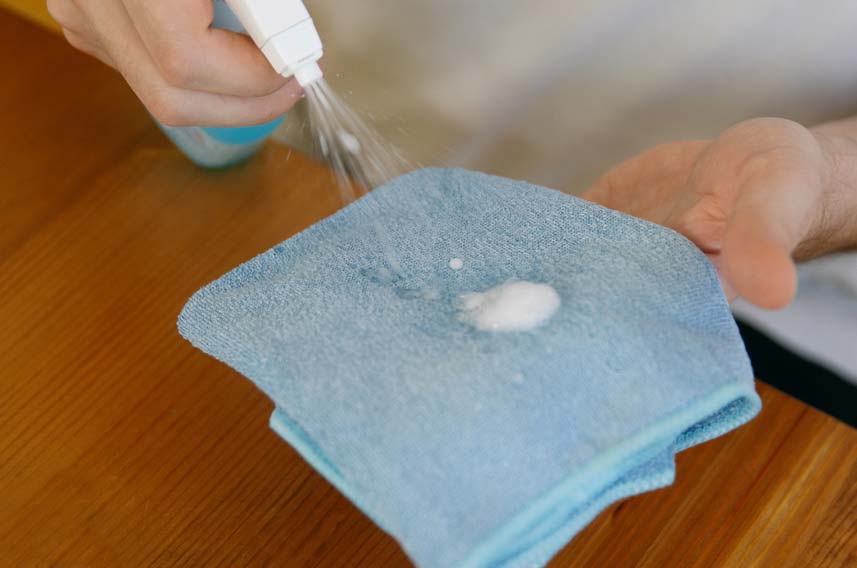 Spraying Cleaner Onto Cloth